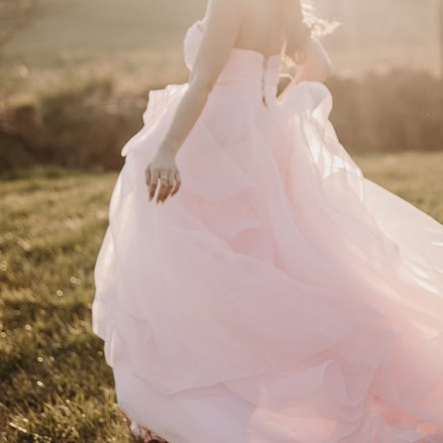 Robe de mariée rose en tulle dans la lumière du soir